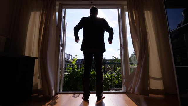 Man In Casual Suit Come And Thrown Open Curtains, Stand Against Full Length Window At Townhouse Bedroom. Low Angle Shot, Sunny Weather Outdoors, Noontime