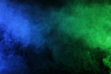 Fototapeta na wymiar Smoke in blue green light on black background
