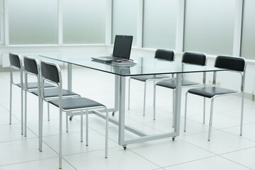 Black chairs glass table stethoscope laptop in office space