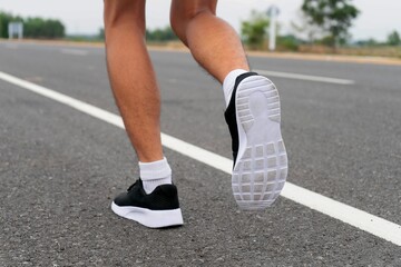 Fototapeta na wymiar Sport running feet on road - healthy concept
