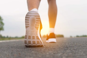 Running feet on road with sunset - healthy concept	