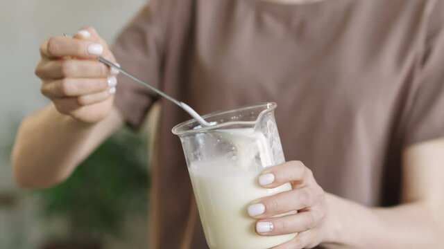 Midsection shot of unrecognizable woman demonstrating smooth consistency of moisturizing handmade body lotion made of shea butter, bee wax and essentials oils