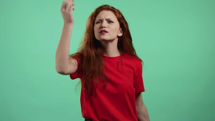 Pretty woman making delicious, perfect gesture. Girl with red hair admires taste of italian food on green studio background. Bellissimo concept.