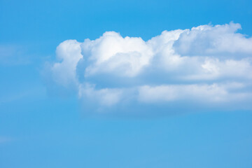 White cumulus clouds on a blue sky background