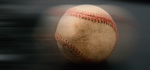 Baseball motion concept with blur behind old used game ball for sport banner.