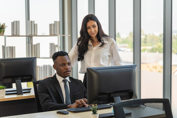Diversity Business and Team Work concept. African businessman and businesswoman team colleague working  with desktop computer in office.