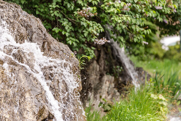 Fototapeta na wymiar Small spring waterfall in the city. The waterfall under the castle of Brno in the Czech Republic.