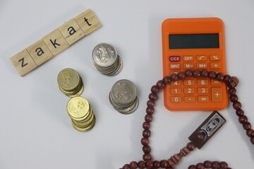 Zakat with coins, prayer beads and calculator