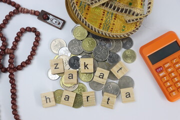 Zakat harta letters with coins, purse , calculator and prayer beads
