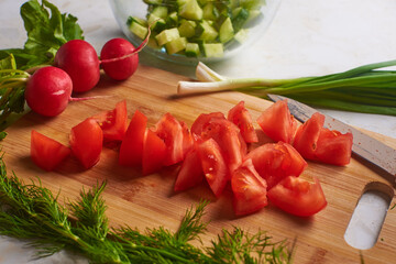 dill red tomato and radish on the board lies