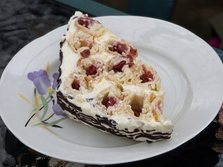 Traditional Russian cake Monastery Hat with sour cherries and white cream, covered with chocolate drizzle