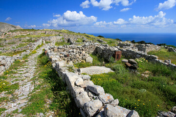 Fototapeta na wymiar Stone ruins of Ancient Thera on Messavouno mountain with blue sky, Santorini, Greece