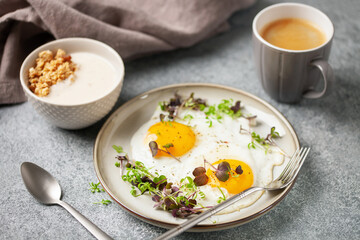 Healthy breakfast. Eggs with micro greens, granola with yogurt and coffee.