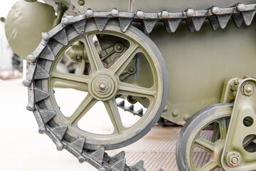 Fototapeta premium Tank of the Second World War. Track armor close-up. Black track link and large rubberized rollers. Tank chassis. The tank stands on a pedestal.Russia, May 9, 2021. Detail of a tracked tank close-up.