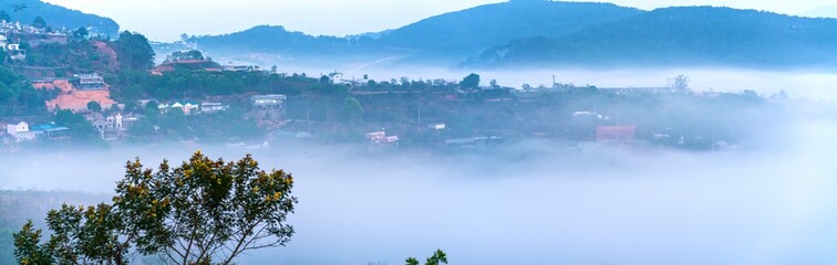 Obraz premium The morning scenery on the hillside in the misty highlands below the beautiful valley