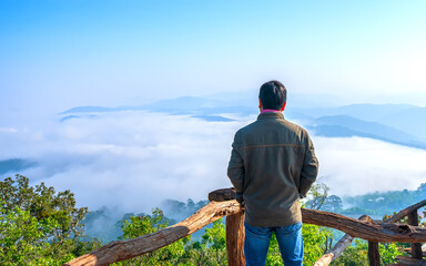 Silhouette of man standing on a high hill scenic rural hometown in the morning valley fog shrouded mountains looming large undulating scenic 