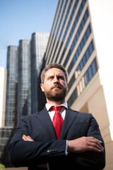 Entrepreneur, business portrait. Businessman standing proud with arms crossed outside.