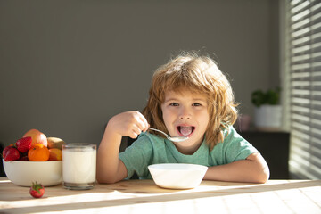 Child eating healthy food at home. Baby eat soup with spoon.