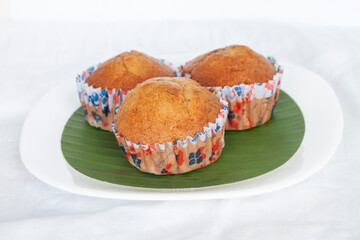 Sweet Banana muffins in white plate on tablecloth.