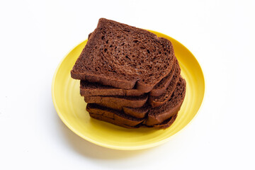 Dark cocoa bread in yellow plate on white