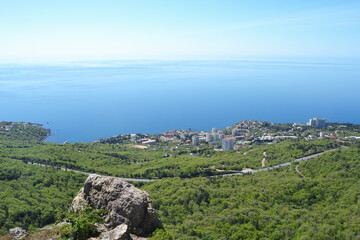 View from the Red Rock to the town of Foros on the Black Sea coast. Crimea. Scenic sea view from above against a bright blue sky.