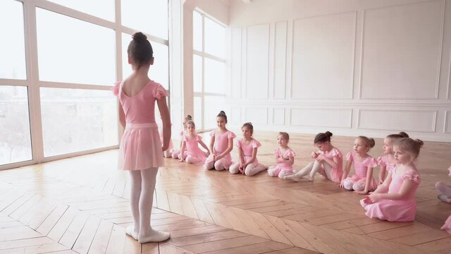 Girls dancers in ballet school learns to dance. Little Ballerinas in training in pink dancing suit. Children's ballet school. School of ballet.