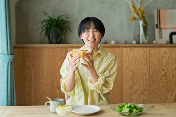 Fotobehang 朝食を食べる女性 © One