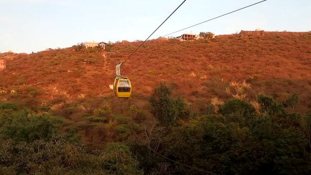 A breathtaking aerial view of the Manshapurn Karni Mata Ropeway in Udaipur, gliding above lush hills and the serene cityscape, offering a stunning blend of nature, devotion, and panoramic beauty.
