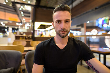 Fototapeta na wymiar Portrait of handsome man sitting at coffee shop