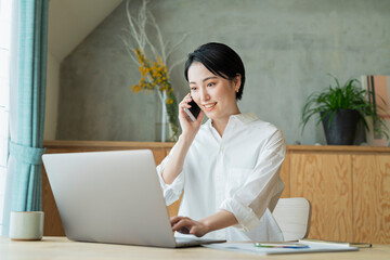 リモートワーク中に電話をする女性
