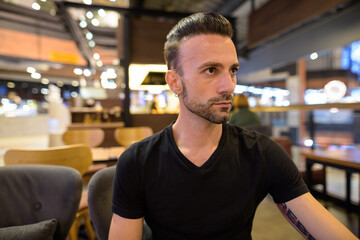 Obraz premium Portrait of handsome man sitting at coffee shop while thinking