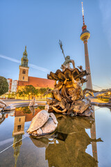 The Neptune Fountain at Alexanderplatz in Berlin at sunrise with the famous Fernsehturm and the...