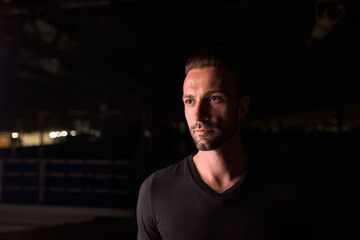 Obraz premium Portrait of handsome man thinking at night in parking lot building