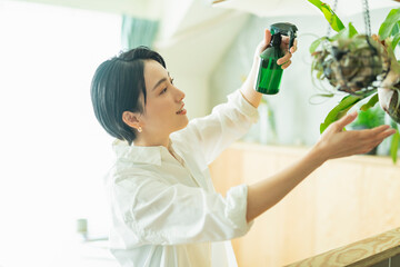 出勤前に観葉植物に水をやる女性