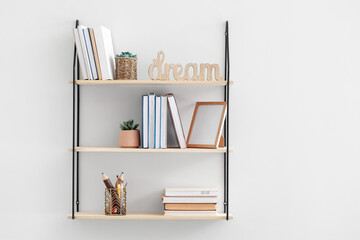 Stylish shelf hanging on light wall