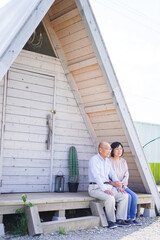 別荘の前に座るシニアの夫婦
