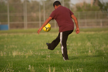 man practicing kicking soccer ball in play grass field wapato washington yakima county