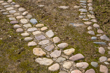 Ancient road paved with natural granite cobblestones.