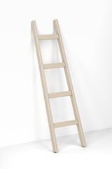 Wooden ladder leaning against the white wall