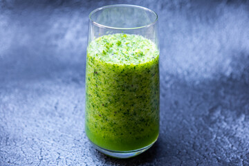 Healthy green smoothie in glass on black background.Detox, vegan, vegetarian healthy vegetable drink.