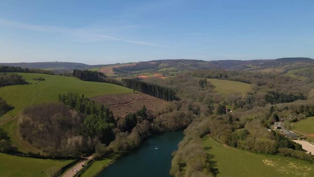 4K flying over hawkridge reservoir, drone moving forward over the water with the trees and the blue sky in the background, 60fps.