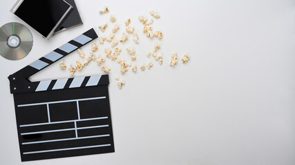 Clapperboard and popcorn on white background. Top view.
