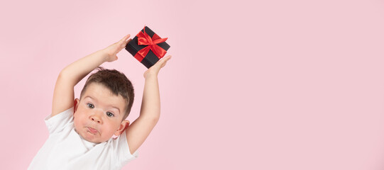 Catch a gift. Little funny boy catches gift box with ribbon, banner