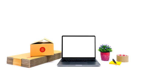 White laptop screen placed on white background Close to each other, there is a parcel box, notepaper, pen, small tree, masking tape with copy space concept. Online sales.