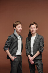 Confident young twins with masks hanging on ears
