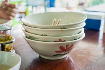 A pile of bowl of noodles that have been eaten. Empty bowl.