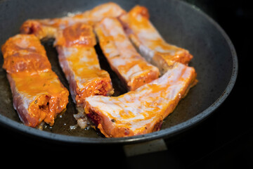Pork ribs meat close-up in a frying pan