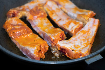 
Pork ribs meat close-up in a frying pan