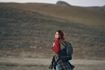 woman in the mountains with a backpack on her shoulders back view travel tourism rock