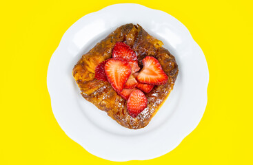 Puff pastry bun or roll. Cake with fresh strawberries. Delicious sweets temptation and desserts on a yellow background. Minimalism, original and creative image. Beautiful food wallpaper.